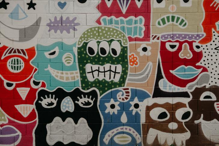 Colorful characters drawn on a brick wall.